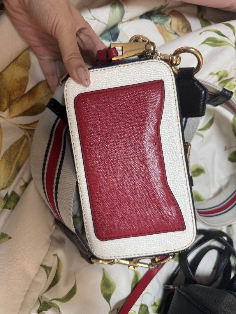 Marc Jacobs Snapshot Camera Bag White Red Blue Strap (Category: Luxury Bags & Wallets) located in Daraga. Submitted by kyotonara1010 (Listing ID 1462606072, Image 3). Description: - Authentic Marc Jacobs Snapshot Bag - Color: White Leather - Hardware: Gold - Includes signature striped strap - Red accent detail on the back - Zipper closure for secure storage - Ideal for everyday use -condition: good condition.