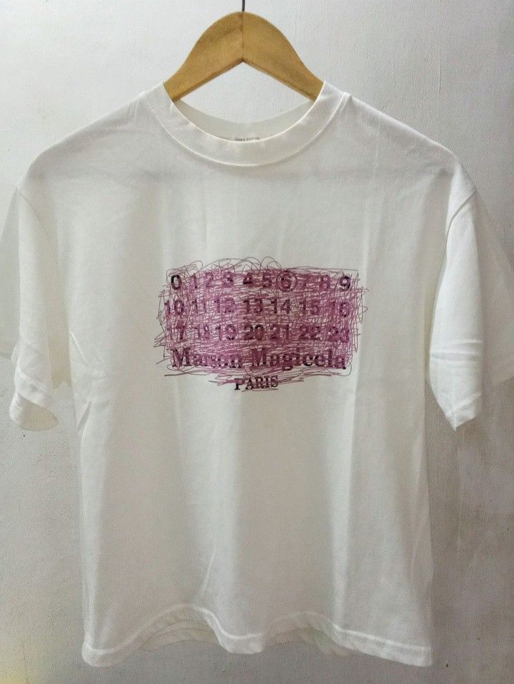 Margiela Numeric logo TShrt (Category: Shirts) located in Manila. Submitted by eriiicaspage (Listing ID 1462449389, Image 1). Description: PreOwned LkeNew Lightly Used Margiela Numers logo t-shirt Medium-Large Cotton - Features the iconic number print with unique scribbled details - Classic crew neck and short sleeve design - Ideal for everyday casual wear No flaws GOod Condition 9/10 .