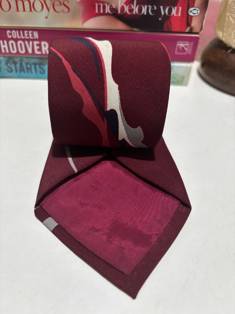 Maroon Silk Tie with Abstract Pattern - Silkoof (Category: Ties) located in Baao. Submitted by apr1979 (Listing ID 1462440590, Image 3). Description: - Stylish maroon silk tie - Features a unique abstract pattern - Colors: Shades of red, white, and blue - Material: 100% Silk - Ideal for formal occasions and elevating work outfits.