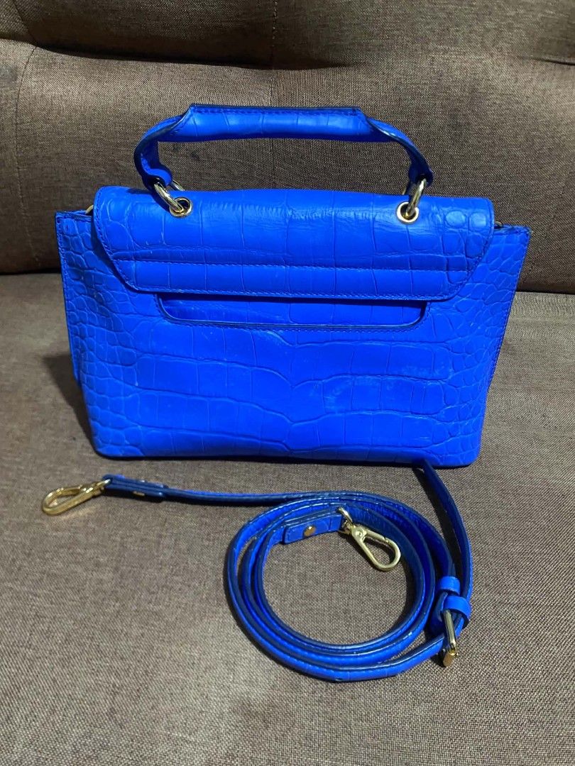 MCM Blue Croc Embossed Top Handle Bag with Strap (Category: Luxury Bags & Wallets) located in Manila. Submitted by buyingprelovedukayukay (Listing ID 1462617471, Image 2). Description: - Vibrant bright blue handbag - Luxurious croc-embossed texture - Convenient top handle - Includes a detachable shoulder strap for versatile wear - Elegant gold hardware details - Protective studs on the bottom to keep it pristine - Adds a stylish pop of color to a