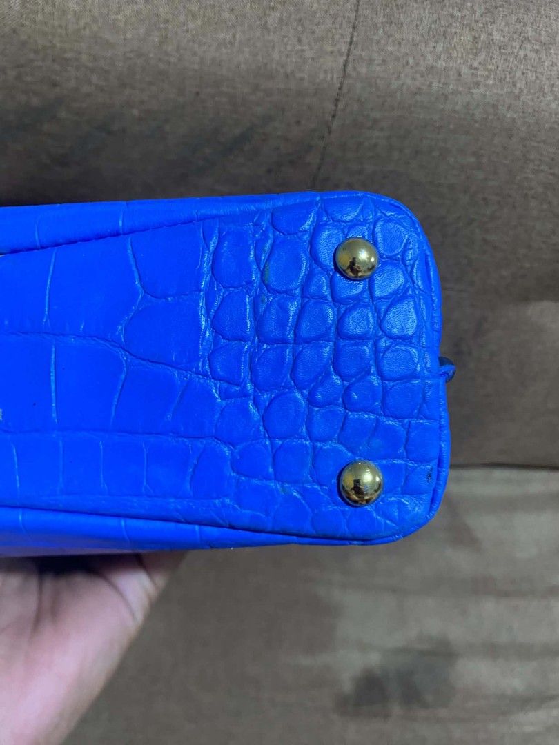 MCM Blue Croc Embossed Top Handle Bag with Strap (Category: Luxury Bags & Wallets) located in Manila. Submitted by buyingprelovedukayukay (Listing ID 1462617471, Image 3). Description: - Vibrant bright blue handbag - Luxurious croc-embossed texture - Convenient top handle - Includes a detachable shoulder strap for versatile wear - Elegant gold hardware details - Protective studs on the bottom to keep it pristine - Adds a stylish pop of color to a