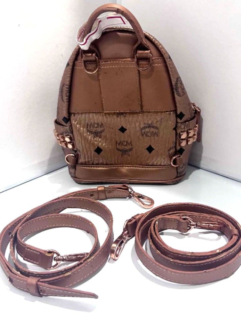 MCM Mini Backpack Rose Gold Studded (Category: Backpacks) located in Antipolo. Submitted by saribymonica (Listing ID 1462502099, Image 2). Description: - Super cute MCM mini backpack - Rose gold color with signature MCM print - Studded details on the front - Comes with two straps: backpack and crossbody - Handle shows some wear - Great for a night out or everyday use -Rose gold MCM - Features the iconic MCM logo pattern throughout - Adorned with 