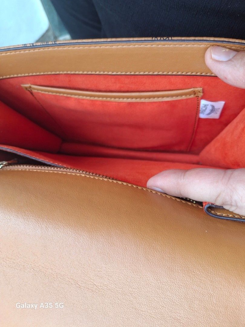 MCM Monogram Shoulder Bag (Category: Luxury Bags & Wallets) located in Cavite. Submitted by bee.geema (Listing ID 1462505984, Image 3). Description: - Authentic MCM monogram shoulder bag - Elegant gold hardware clasp closure - Interior: 1 zippered pocket, 1 slip pocket - Luxurious orange suede lining - Comes with a small leather tag - Adjustable strap for comfortable wear.