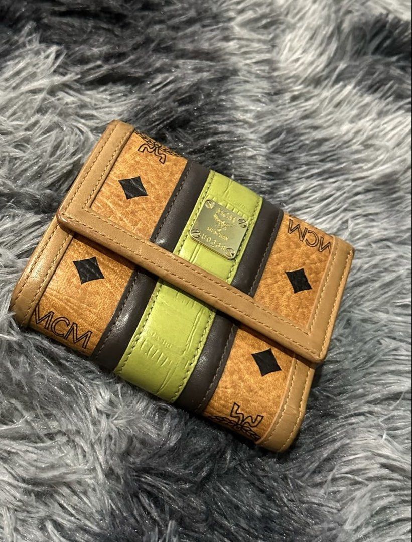 MCM Monogram Trifold Wallet (Category: Luxury Bags & Wallets) located in Manila. Submitted by dapixphot28865 (Listing ID 1462456619, Image 1). Description: - Authentic MCM trifold wallet - Classic monogram pattern - Brown and lime green accents - Small metal logo plate on front - Compact size, perfect for essentials - Shows some signs of wear, still functional.