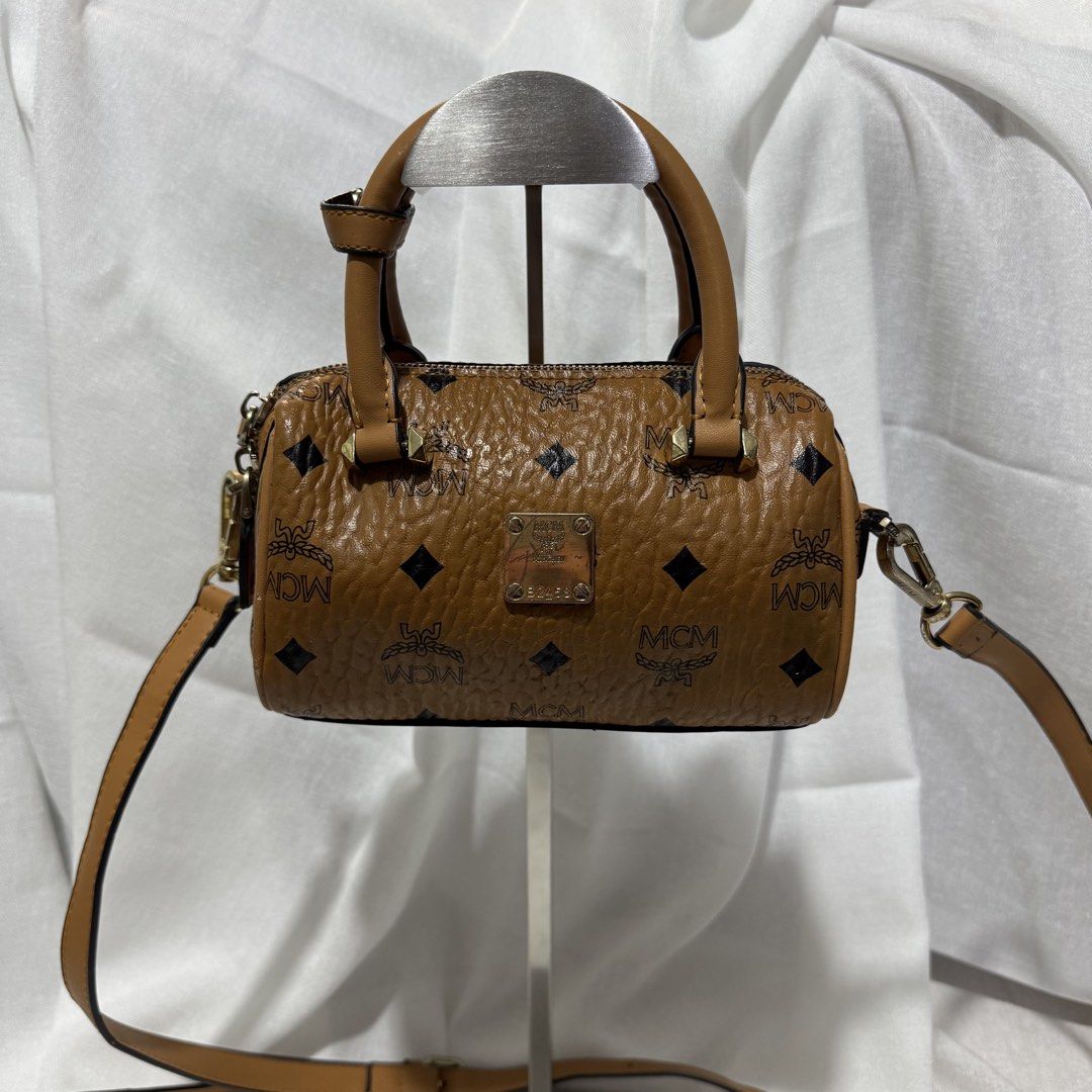 MCM Visetos Mini Duffle Bag Brown (Category: Luxury Bags & Wallets) located in Las Pinas. Submitted by declutterqueen_00 (Listing ID 1462657290, Image 2). Description: ✨ Preloved Collection Note ✨ Please manage expectations as these are preloved items. Authenticity is not guaranteed, but serial/date codes are present. Sold as-is. - Classic Visetos print - Small size, ideal for essentials - Top handles - Detachable shoulder strap - Gold-tone hardw