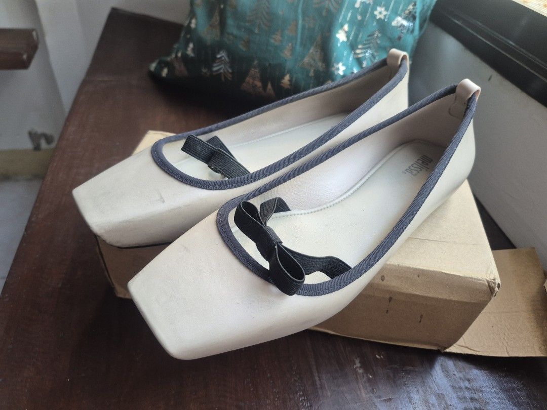 Melissa Ballet Flats Square Toe Bow Detail (Category: Flats & Sandals) located in Leyte. Submitted by melinda66885 (Listing ID 1462442529, Image 2). Description: - Melissa ballet flats - Light beige color - Cute black bow detail on the front - Dark grey trim - Square toe - Made in Brazil.