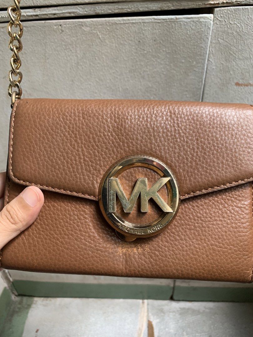 Michael Kors Brown Leather Wallet on Chain (Category: Luxury Bags & Wallets) located in Manila. Submitted by usagichan_rabbit (Listing ID 1462455261, Image 2). Description: - Brown pebbled leather wallet on chain - Gold Michael Kors (MK) logo hardware - Interior includes card slots and a zip pocket - Gold-tone chain strap - Ideal for carrying your essentials Sign of usage please manage your expectation..