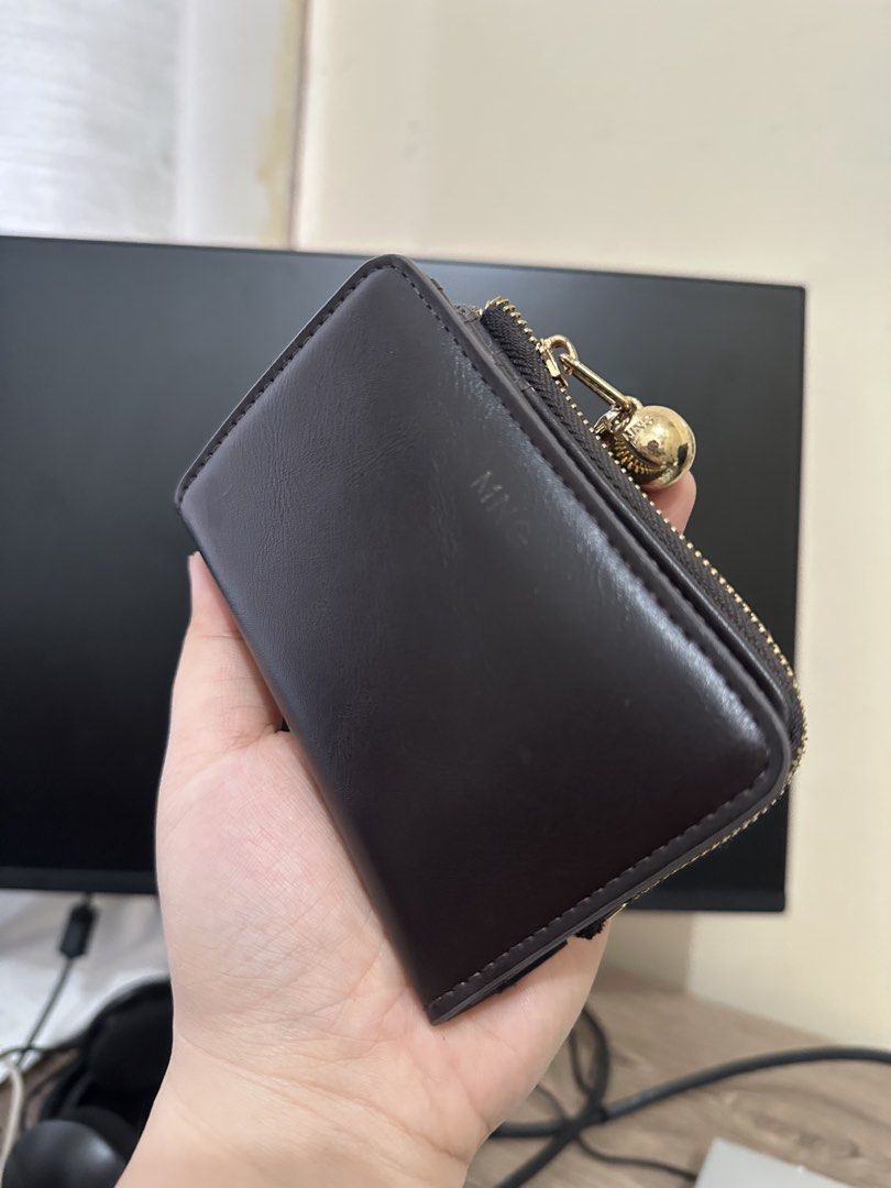MNG Brown Zipper Wallet (Category: Wallets & Card holders) located in Dasmarinas. Submitted by paulaaa_ (Listing ID 1462444666, Image 1). Description: - Brown MNG wallet - Zipper closure - Multiple card slots inside - Small and compact design - Gold hardware with ball charm detail - Ideal for organizing cards and cash.