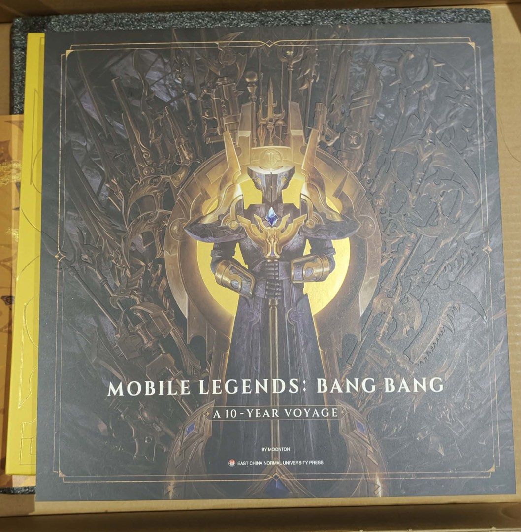 Mobile Legends BangBang 10-Year Voyage (Category: In-Game Products) located in Manila. Submitted by joandaise0125 (Listing ID 1462592818, Image 2). Description: The artbook comes packaged inside a premium gold-themed collector’s edition box set. The bundle includes: - Canvas Tote Bag - 6 Exclusive Postcards - Clear Collectible Cards - MLBB Sticker Pack.