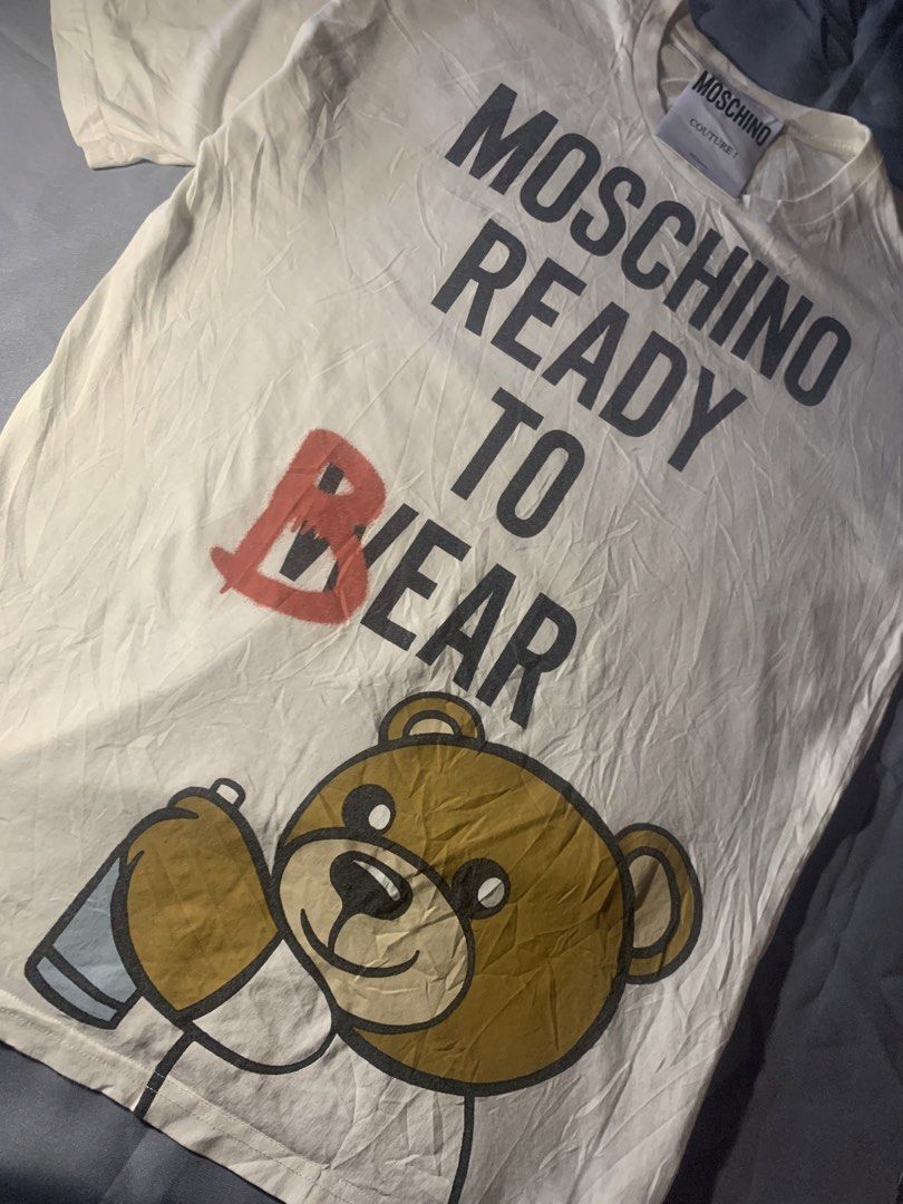 Moschino ready to bear shirt (Category: Luxury Apparel) located in General Santos City (Dadiangas). Submitted by stockyards (Listing ID 1462558866, Image 3). Description: Brand: moschino • excellent | no issue • 9.5/10 color rate • need wash * FREESHIPPING PH Actual dimes Width: 21 Length: 28 Price: 749 General santos city mindanao 9500📍 .