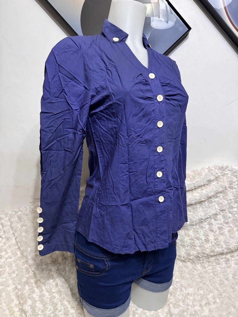 Navy Blue Button-Up Blouse with Collar Detail (Category: Longsleeves) located in Marikina City. Submitted by lorradel (Listing ID 1462459857, Image 2). Description: - fits s-m - Navy blue long-sleeved blouse - Unique stand-up collar with button details - Button-up front with ruched detailing - Button accents on cuffs - Versatile: pairs well with shorts or jeans - MAY HAVE some washable stains (hindi maiiwasan) needs washing; had been stored - man