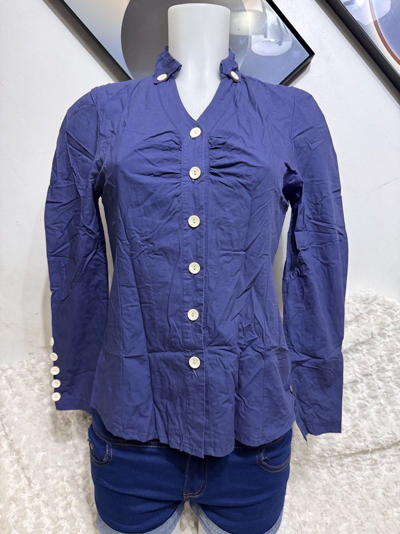 Navy Blue Button-Up Blouse with Collar Detail (Category: Longsleeves) located in Marikina City. Submitted by lorradel (Listing ID 1462459857, Image 1). Description: - fits s-m - Navy blue long-sleeved blouse - Unique stand-up collar with button details - Button-up front with ruched detailing - Button accents on cuffs - Versatile: pairs well with shorts or jeans - MAY HAVE some washable stains (hindi maiiwasan) needs washing; had been stored - man