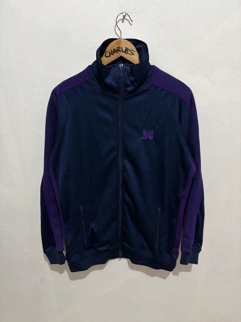 Needles Track Jacket Navy Purple Butterfly Logo Poly Smooth (Category: Coats, Jackets and Outerwear) located in Cabanatuan. Submitted by chingweyyy (Listing ID 1462619341, Image 1). Description: - Brand: Needles - Color: Navy Blue - Design: Purple stripe details on sleeves and shoulders - Logo: Embroidered butterfly on chest - Closure: Zipper - Pockets: Two front pockets - Size: L - Style: Great for casual wear - 24 Width x 28 Length.