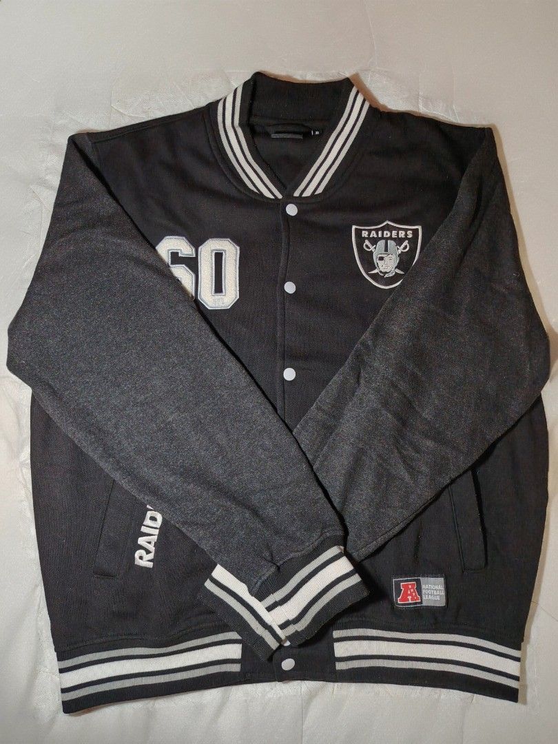 NFL Las Vegas Raiders Varsity Jacket XL (Category: Coats, Jackets and Outerwear) located in Manila. Submitted by charlize.kate2026 (Listing ID 1462471133, Image 1). Description: - Black and grey Las Vegas Raiders varsity jacket - Features Raiders logo on chest - 'Raiders' embroidered on sleeve - Number '60' on the front - NFL Team Apparel tag - Ribbed cuffs and collar for a snug fit - Classic snap button closure.