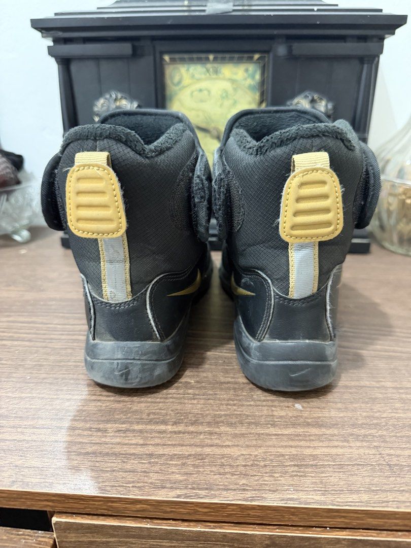 Nike Black Winter Boots in 32eur (Category: Babies & Kids Fashion) located in Binan City. Submitted by prelovedlagunaph (Listing ID 1462624006, Image 3). Description: - Black Nike mid-calf winter boots - Padded upper for warmth - Gold Nike logos on tongue and side - Easy velcro strap closure - Convenient pull tabs at the back - Durable sole with excellent grip - Ideal for cold weather conditions.