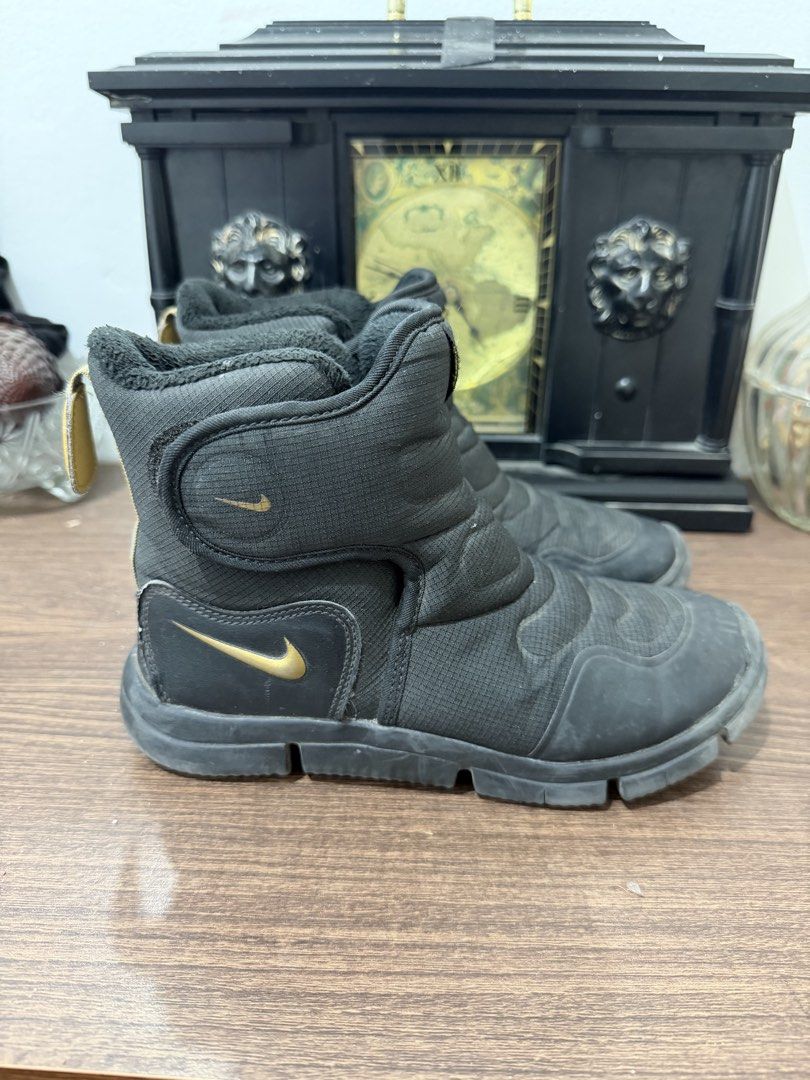 Nike Black Winter Boots in 32eur (Category: Babies & Kids Fashion) located in Binan City. Submitted by prelovedlagunaph (Listing ID 1462624006, Image 2). Description: - Black Nike mid-calf winter boots - Padded upper for warmth - Gold Nike logos on tongue and side - Easy velcro strap closure - Convenient pull tabs at the back - Durable sole with excellent grip - Ideal for cold weather conditions.