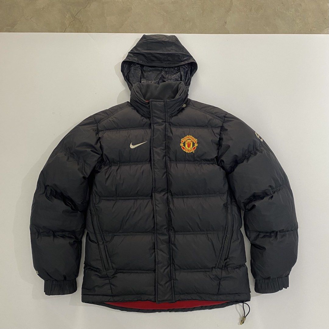 Nike Manchester United Puffer Jacket (Category: Coats, Jackets and Outerwear) located in Manila. Submitted by eddjohn (Listing ID 1462562963, Image 1). Description: - Authentic Manchester United x Nike puffer jacket - Stylish black design with iconic logos - Cozy hooded style with a vibrant red lining - Made in Vietnam, Size S (165/84A) - Filled with warm grey duck down and feathers - Ideal for keeping warm during colder seasons - Large fit mens.
