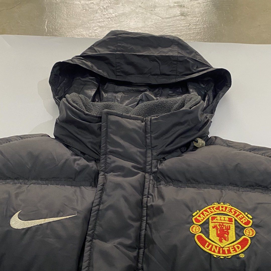 Nike Manchester United Puffer Jacket (Category: Coats, Jackets and Outerwear) located in Manila. Submitted by eddjohn (Listing ID 1462562963, Image 2). Description: - Authentic Manchester United x Nike puffer jacket - Stylish black design with iconic logos - Cozy hooded style with a vibrant red lining - Made in Vietnam, Size S (165/84A) - Filled with warm grey duck down and feathers - Ideal for keeping warm during colder seasons - Large fit mens.