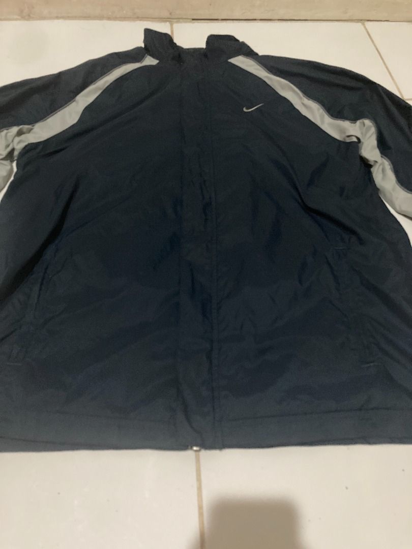 Nike Vintage 90s small logo windbreaker (Category: Coats, Jackets and Outerwear) located in Angono. Submitted by jc_ilagan (Listing ID 1462471954, Image 2). Description: - Classic Nike windbreaker jacket - Color: Navy blue with light grey accents on sleeves and sides - Material: Lightweight, perfect for layering or light rain protection - Features: Front pockets, drawstring at the bottom hem - Style: Versatile for casual wear or sports activities