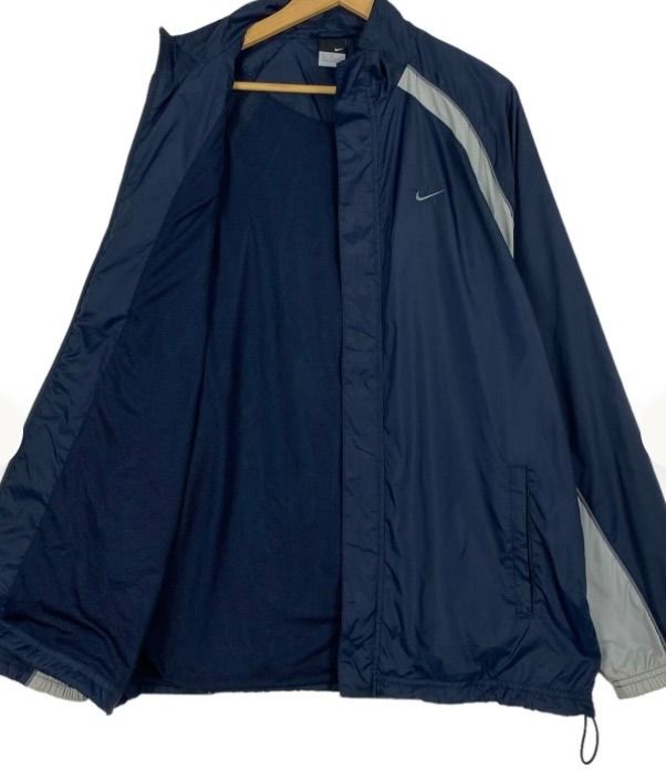 Nike Vintage 90s small logo windbreaker (Category: Coats, Jackets and Outerwear) located in Angono. Submitted by jc_ilagan (Listing ID 1462471954, Image 1). Description: - Classic Nike windbreaker jacket - Color: Navy blue with light grey accents on sleeves and sides - Material: Lightweight, perfect for layering or light rain protection - Features: Front pockets, drawstring at the bottom hem - Style: Versatile for casual wear or sports activities