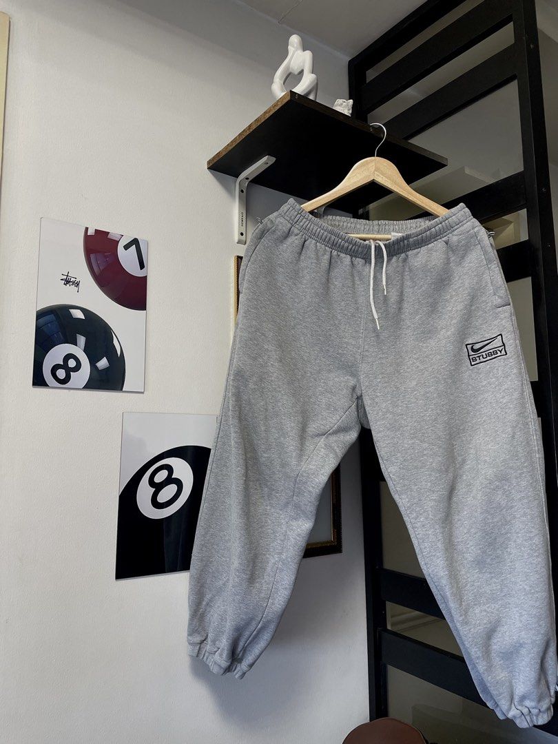Nike x Stussy Grey Sweatpants Size M (Category: Joggers) located in Manila. Submitted by cis_thrift143 (Listing ID 1462533202, Image 1). Description: - Authentic Nike x Stussy collaboration grey sweatpants. - Features the iconic Stussy logo combined with the Nike swoosh. - Adjustable drawstring waist for a comfortable, personalized fit. - Elasticated cuffs for a snug and stylish look. - Size: Medium. - Ideal for everyday casual wear and streetwea