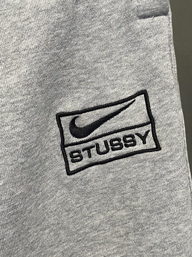 Nike x Stussy Grey Sweatpants Size M (Category: Joggers) located in Manila. Submitted by cis_thrift143 (Listing ID 1462533202, Image 2). Description: - Authentic Nike x Stussy collaboration grey sweatpants. - Features the iconic Stussy logo combined with the Nike swoosh. - Adjustable drawstring waist for a comfortable, personalized fit. - Elasticated cuffs for a snug and stylish look. - Size: Medium. - Ideal for everyday casual wear and streetwea