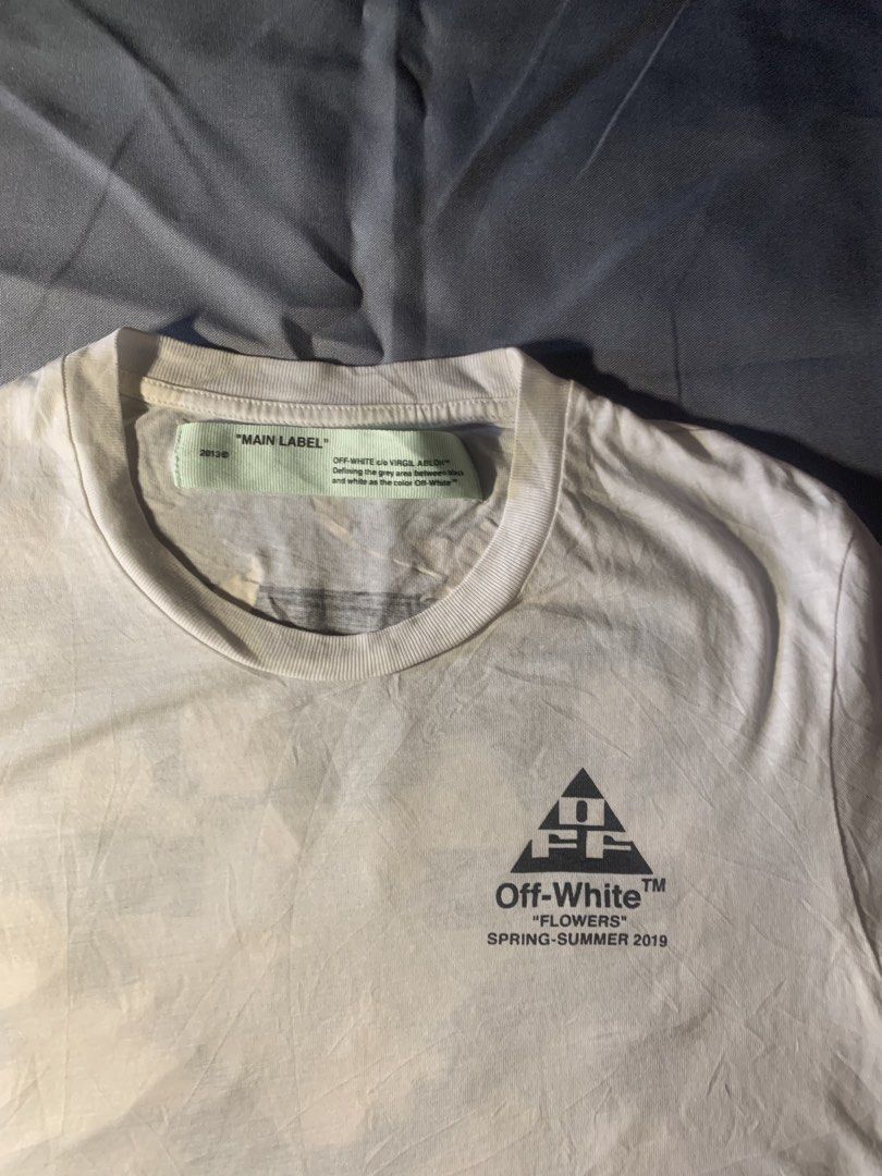 OFF-WHITE "Flowers" T-shirt Spring-Summer 2019 (Category: Luxury Apparel) located in General Santos City (Dadiangas). Submitted by stockyards (Listing ID 1462562202, Image 3). Description: - Authentic Off-White T-Shirt - Collection: Spring-Summer 2019 - Color: White - Iconic Off-White arrow logo on back - Unique floral print detail on back - Small graphic print on front chest - Material: 100% Cotton - Condition: Brand new with tags still attached