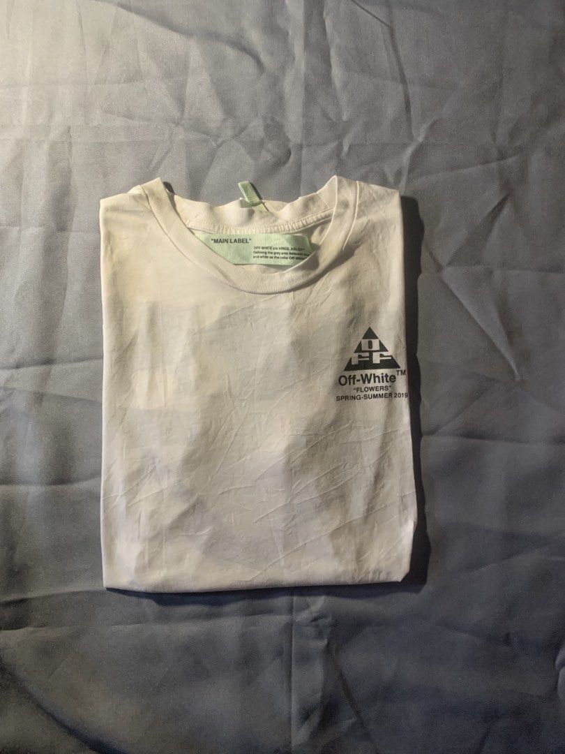 OFF-WHITE "Flowers" T-shirt Spring-Summer 2019 (Category: Luxury Apparel) located in General Santos City (Dadiangas). Submitted by stockyards (Listing ID 1462562202, Image 2). Description: - Authentic Off-White T-Shirt - Collection: Spring-Summer 2019 - Color: White - Iconic Off-White arrow logo on back - Unique floral print detail on back - Small graphic print on front chest - Material: 100% Cotton - Condition: Brand new with tags still attached