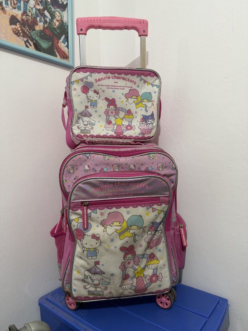 Pink Sanrio Characters Rolling Backpack with Matching Lunch Bag (Category: Backpacks) located in Binan City. Submitted by prelovedlagunaph (Listing ID 1462620155, Image 1). Description: - Adorable pink Sanrio rolling backpack set - Features beloved characters: Kitty, My Melody, and Little Twin Stars - Main backpack with wheels and retractable handle for easy rolling - Adjustable shoulder straps for comfortable carrying - Includes a matching small