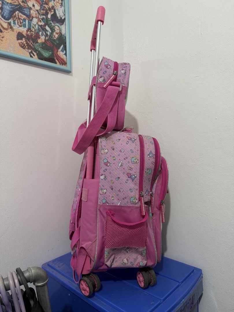Pink Sanrio Characters Rolling Backpack with Matching Lunch Bag (Category: Backpacks) located in Binan City. Submitted by prelovedlagunaph (Listing ID 1462620155, Image 2). Description: - Adorable pink Sanrio rolling backpack set - Features beloved characters: Kitty, My Melody, and Little Twin Stars - Main backpack with wheels and retractable handle for easy rolling - Adjustable shoulder straps for comfortable carrying - Includes a matching small