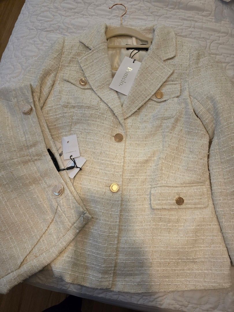 Pomelo Tweed Blazer and Short set (Category: Sets or Coordinates) located in Taguig. Submitted by jubeiqiao03 (Listing ID 1462539133, Image 1). Description: - Pomelo tweed blazer and skirt set - Color: Creamy beige - Gold button details - Blazer: Double-breasted front, pocket details - Skirt: Button closure - Creates a chic, put-together look - Never worn, tags still attached.