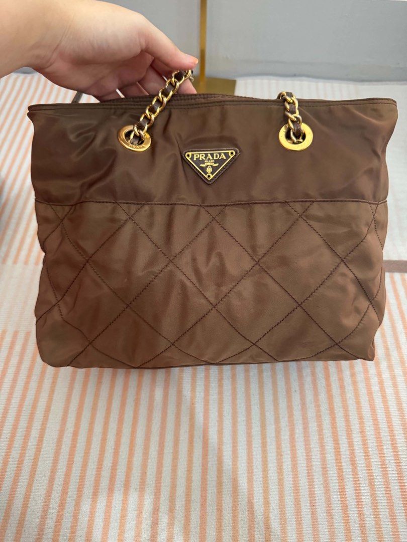 Prada Brown Quilted Nylon Chain Shoulder Bag (Category: Luxury Bags & Wallets) located in Bocaue. Submitted by stuart0101 (Listing ID 1462587463, Image 2). Description: - Authentic brown Prada shoulder bag - Quilted nylon material - Gold chain straps - Prada logo lining interior - Great everyday bag - Plenty of space inside.