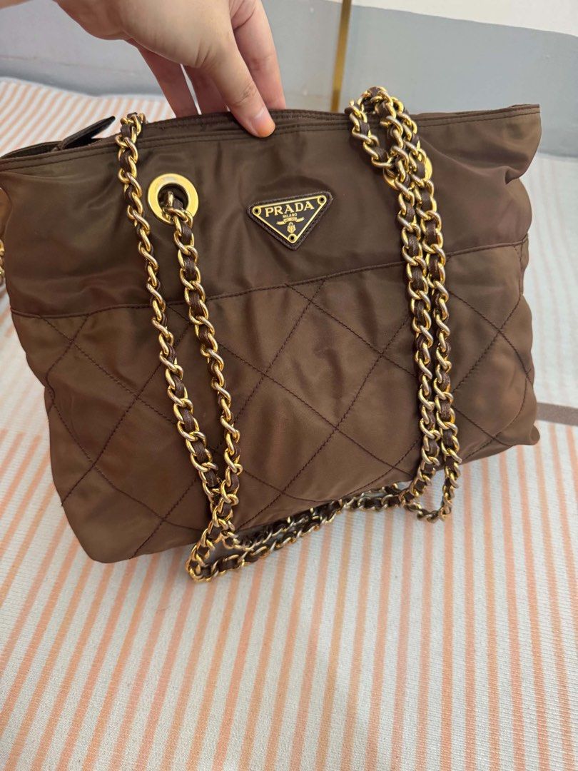 Prada Brown Quilted Nylon Chain Shoulder Bag (Category: Luxury Bags & Wallets) located in Bocaue. Submitted by stuart0101 (Listing ID 1462587463, Image 3). Description: - Authentic brown Prada shoulder bag - Quilted nylon material - Gold chain straps - Prada logo lining interior - Great everyday bag - Plenty of space inside.