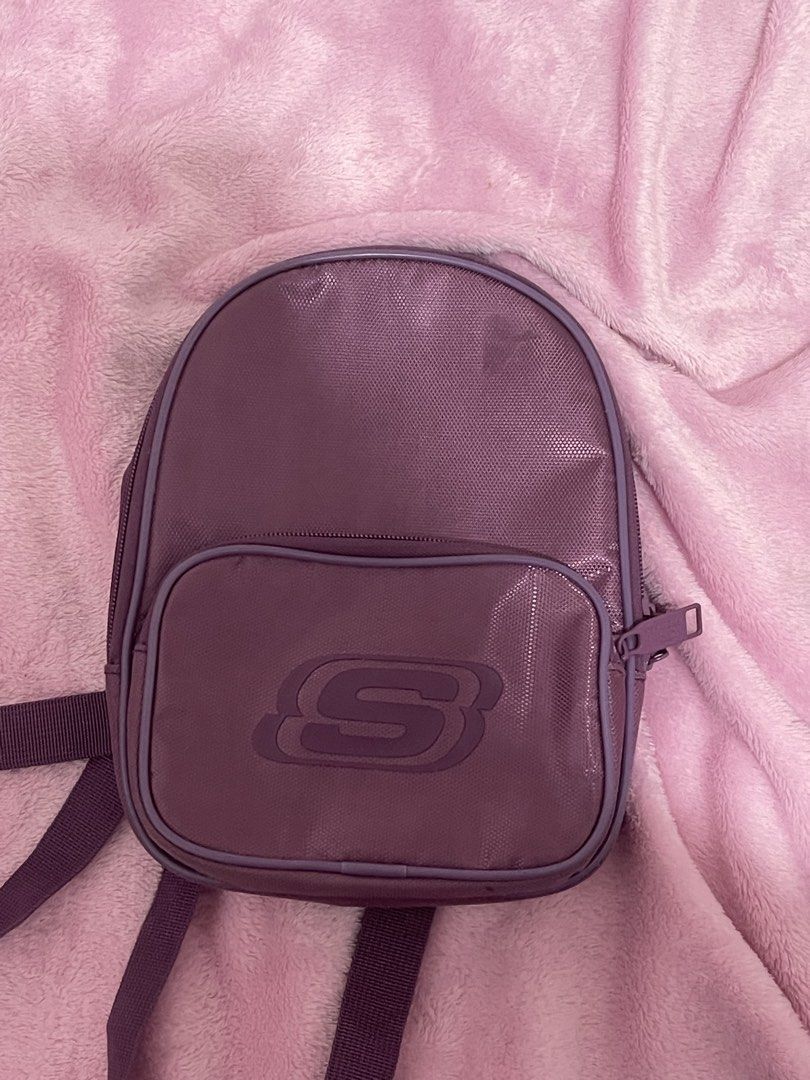 Purple Skechers Mini Backpack (Category: Backpacks) located in Manila. Submitted by boldflower.98829f (Listing ID 1462678906, Image 1). Description: - Cute purple mini backpack from Skechers - Features the iconic S logo on the front pocket - Includes a main compartment and a front zip pocket for organization - Adjustable straps for a comfortable fit - Ideal for everyday use or travel adventures.