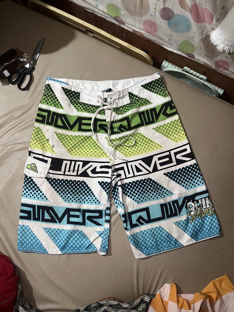Quiksilver Board Shorts Size 36 (Category: Swim Trunks & Board Shorts) located in Lapu Lapu. Submitted by vanzfinds_16 (Listing ID 1462615642, Image 1). Description: - Quiksilver Board Shorts - Size: 36 - Design: Bold geometric and dot pattern (white, green, blue, black) - Features: Velcro pocket on right side, adjustable drawstring waist - Ideal for: Swimming, lounging, beach activities.