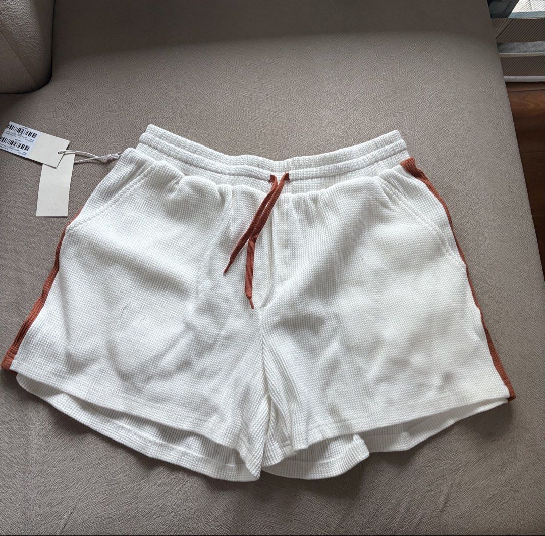Recess White Waffle Knit Drawstring Shorts Size 2 (Category: Shorts) located in Muntinlupa City. Submitted by secondhandlove12345 (Listing ID 1462499307, Image 1). Description: - Brand: Recess - Style: White waffle knit shorts - Size: 2 - Features: Drawstring waist, contrasting rust-colored side stripes - Perfect for: Lounging, casual wear - Comfort: Comfortable and stylish.
