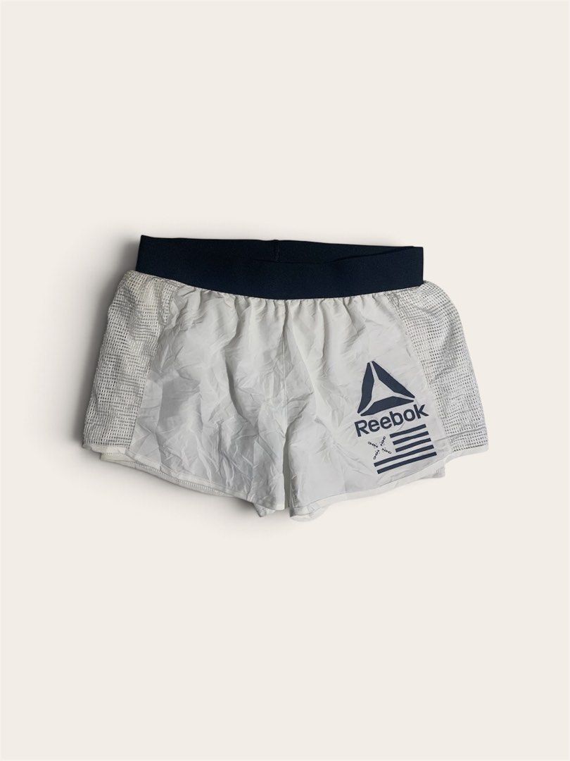 Reebok White Running Shorts with Mesh Panels (Category: Activewear) located in Davao. Submitted by youngboythrift25 (Listing ID 1462610107, Image 2). Description: - White Reebok running shorts - Dark blue waistband - Side mesh panels for enhanced breathability - Reebok logo and graphic print on the front - Lightweight material, ideal for workouts or casual wear - Elastic waistband for a comfortable and secure fit.