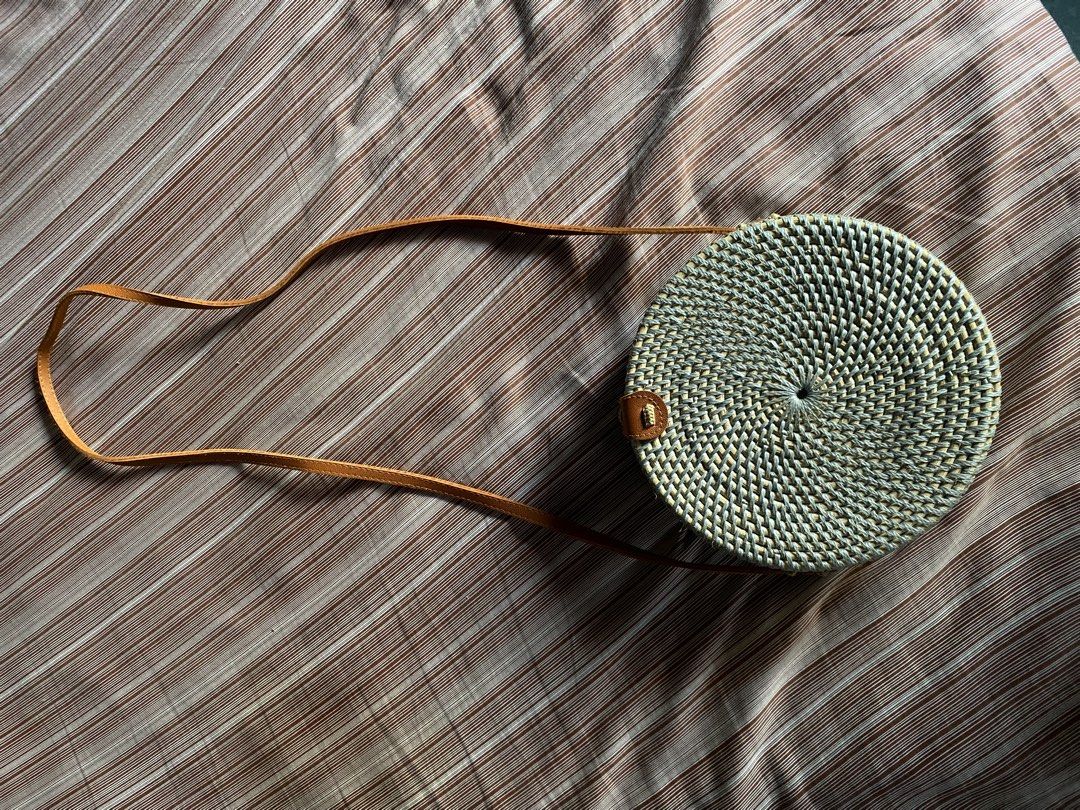 Round Rattan Sling Bag with Leather Strap (Category: Cross-body Bags) located in Silang. Submitted by iamjhestine (Listing ID 1462670556, Image 1). Description: - Cute round rattan bag - Natural woven material - Comes with a brown leather strap - Ideal for beach trips or casual outings - Small size, perfect for essentials - Unique texture and design.