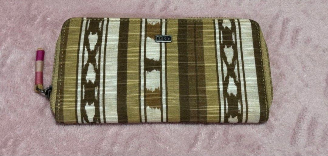 Roxy Zip Around Wallet (Category: Wallets & Card holders) located in Pasay City. Submitted by szepter (Listing ID 1462445529, Image 1). Description: - Roxy wallet with a cool striped pattern. - Ample card slots for all your cards. - Zippered coin pocket inside for loose change. - Secure zipper closure to keep everything safe. - Features a pleasant textured fabric. - Ideal for keeping your essentials organized..