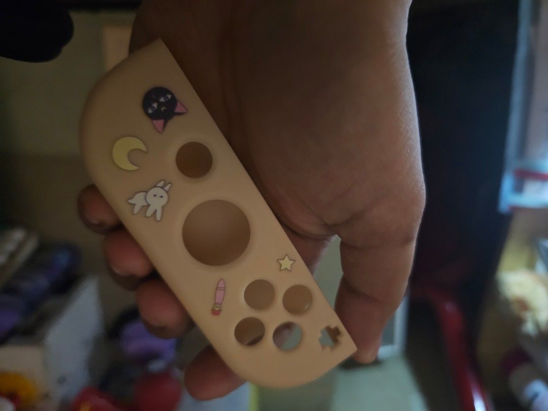 Sailor Moon Nintendo Switch Joy-Con Protective Case (Category: Controllers) located in Quezon City. Submitted by ame_1234 (Listing ID 1462529435, Image 3). Description: - Cute Sailor Moon themed protective case for Nintendo Switch Joy-Cons. - Lovely pastel peach color with adorable Sailor Moon characters and motifs. - Protects controllers from scratches and bumps. - Easy to snap on and off. - Great for fans of Sailor Moon!.