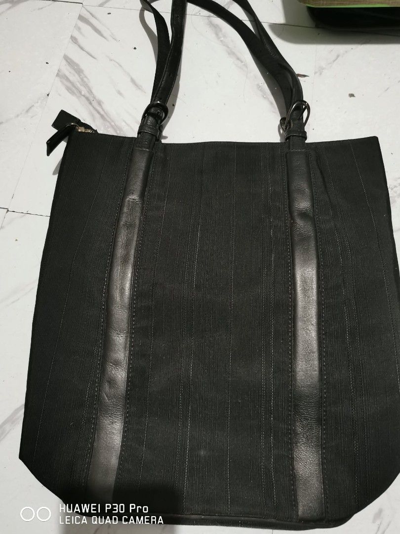 Sazaby Black Tote Bag (Category: Tote Bags) located in Makati City. Submitted by relianzmae57131 (Listing ID 1462471832, Image 3). Description: - Sazaby tote bag in classic black. - Crafted from textured fabric with elegant leather accents. - Secure zippered top closure. - Interior features a convenient zippered pocket. - Durable metal studs on the base for protection. - Comfortable shoulder straps for easy carrying..
