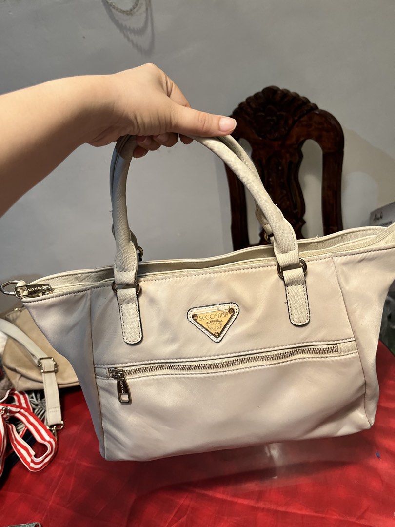 Secosana Beige Satchel Handbag (Category: Luxury Bags & Wallets) located in Manila. Submitted by harpymonetttt (Listing ID 1462650631, Image 2). Description: - Brand: Secosana - Color: Milk white/ cream - Style: Two way bag (sling/ shoulder bag) - Features: Front zip pocket, top zip closure, two top handles - Hardware: Gold-tone - Condition: Sight washable dust stain on front - Ideal for: Everyday use and office wear.
