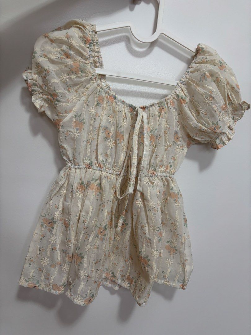Sheer Floral Puff Sleeve Top with Tie Front (Category: Blouses) located in Quezon City. Submitted by janahvilla37434 (Listing ID 1462477330, Image 2). Description: - Cream sheer top - Delicate floral print - Puff sleeves - Gathered waist - Tie front detail - Lightweight and airy fabric - Perfect for layering or wearing solo.