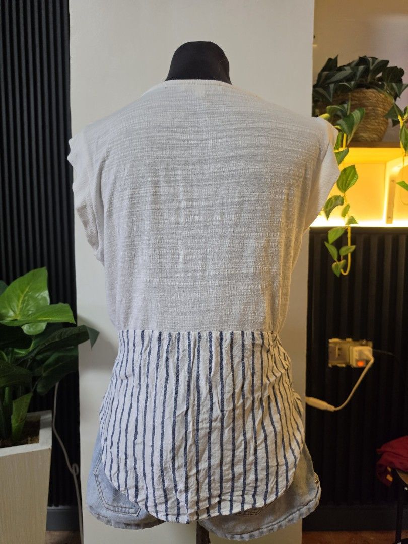 Skies Are Blue White Striped Patchwork Top Size S to medium (Category: Sleeveless) located in Paranaque City. Submitted by franinnashop (Listing ID 1462501850, Image 3). Description: - Unique white top with blue striped patchwork detail. - Features textured fabric on front and back. - Short sleeves and a stylish keyhole neckline with button closure. - Versatile design, pairs perfectly with jeans or shorts. - Comfortable and fashionable for everyd