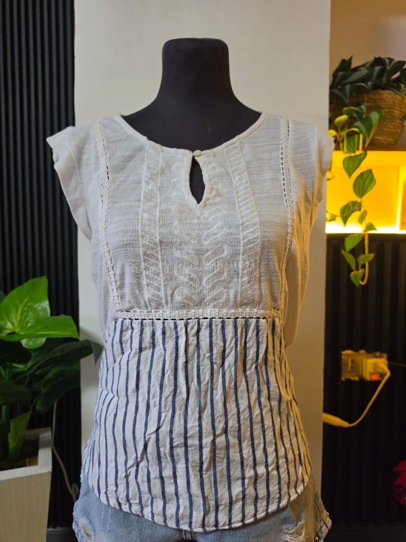 Skies Are Blue White Striped Patchwork Top Size S to medium (Category: Sleeveless) located in Paranaque City. Submitted by franinnashop (Listing ID 1462501850, Image 1). Description: - Unique white top with blue striped patchwork detail. - Features textured fabric on front and back. - Short sleeves and a stylish keyhole neckline with button closure. - Versatile design, pairs perfectly with jeans or shorts. - Comfortable and fashionable for everyd