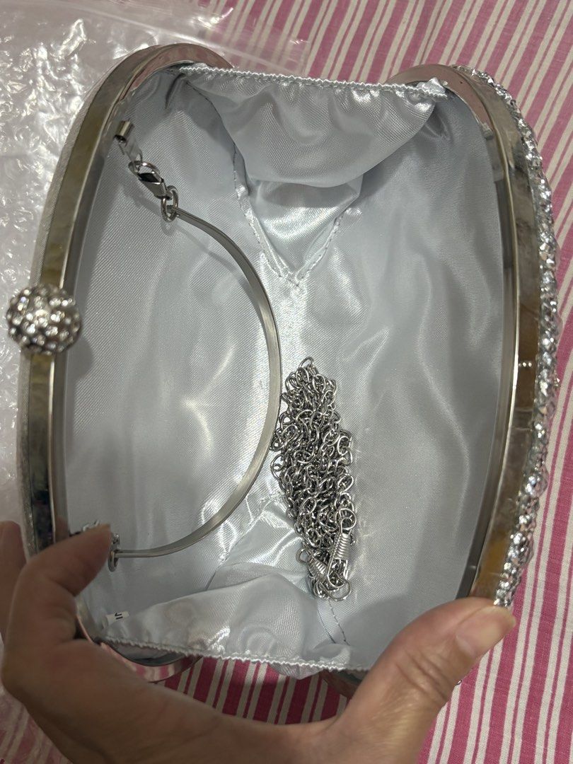 Sparkly Rhinestone Clutch Bag with Chain Strap (Category: Clutches) located in Manila. Submitted by nykji96 (Listing ID 1462536208, Image 3). Description: - Dazzling oval clutch bag covered in rhinestones. - Features a detachable silver chain strap for versatile wear. - Luxurious satin lining inside. - Secure clasp closure at the top. - Ideal for parties, weddings, and special occasions. - Dimensions: Approximately 8 inches wide and 5 inches tall
