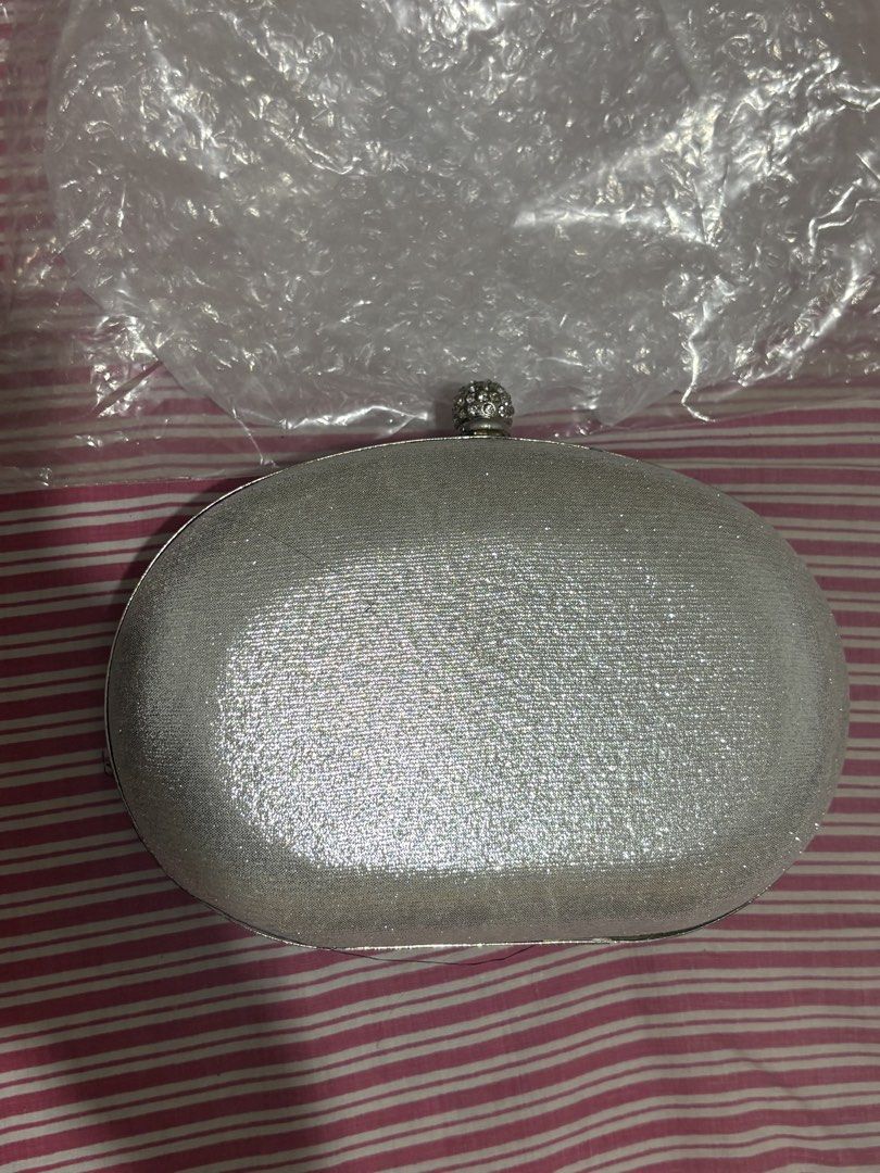 Sparkly Rhinestone Clutch Bag with Chain Strap (Category: Clutches) located in Manila. Submitted by nykji96 (Listing ID 1462536208, Image 2). Description: - Dazzling oval clutch bag covered in rhinestones. - Features a detachable silver chain strap for versatile wear. - Luxurious satin lining inside. - Secure clasp closure at the top. - Ideal for parties, weddings, and special occasions. - Dimensions: Approximately 8 inches wide and 5 inches tall