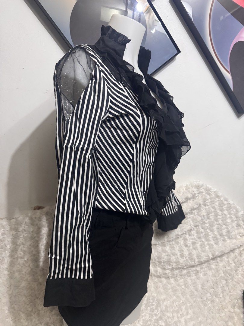 Striped Ruffle Blouse with Sheer Sleeves (Category: Longsleeves) located in Marikina City. Submitted by lorradel (Listing ID 1462461213, Image 3). Description: - fits M- L 34 bust - Classic black and white stripes - Ruffled front detail - Sheer sleeves with subtle embellishments - Button-up closure - Versatile for professional or chic outfits - Looks great tucked into skirts or trousers - MAY HAVE some washable stains (hindi maiiwasan) needs wash