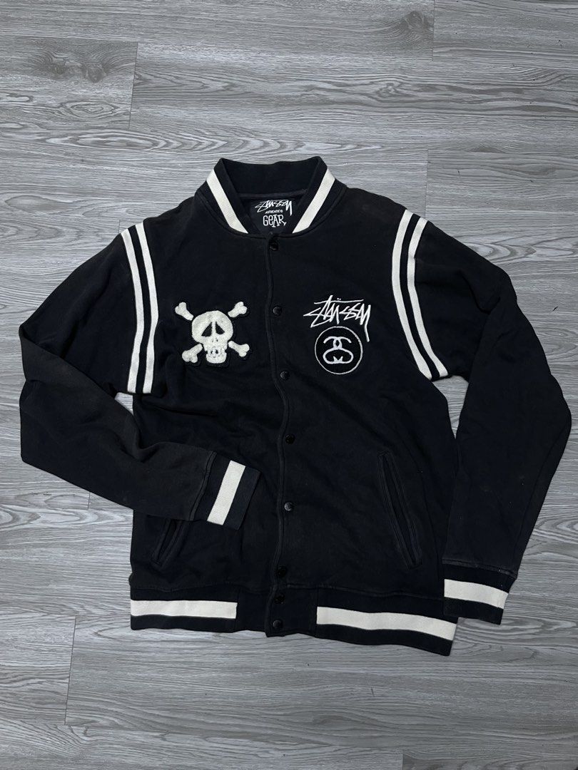 Stussy Skull & Crossbones Varsity Jacket (Category: Coats, Jackets and Outerwear) located in Manila. Submitted by yourfavoriteplug (Listing ID 1462507685, Image 1). Description: - Classic Black Stussy Varsity Jacket - White striped sleeves and collar for a retro look - Unique skull and crossbones patch on left chest - Prominent Stussy logos on right chest and back - Easy button-up closure - Size Large (L).