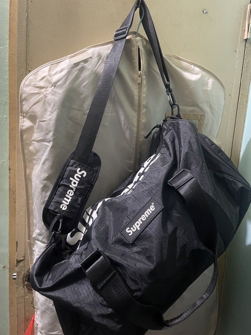 Supreme Duffle Bag Black White Logo (Category: Sling Bags) located in Baguio. Submitted by claw_set (Listing ID 1462590783, Image 1). Description: - Stylish black duffle bag with iconic white Supreme logo. - Versatile carrying options: comfortable shoulder strap and sturdy top handles. - Convenient interior zippered pocket for secure storage. - Ideal for your next travel adventure or gym sessions. .